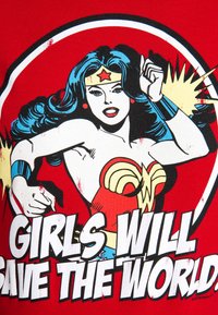 Red graphic t-shirt featuring a comic-style illustration of a superhero woman, with white text reading "GIRLS WILL SAVE THE WORLD."