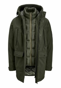 Olijfgroene, gelaagde jas met een afneembare puffer binnenkant, verweven stof, voorzakken en een capuchon. Rits- en drukknoopsluiting.