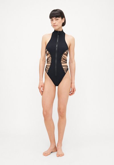 Black one-piece swimsuit with high neck and front zipper, featuring side cutouts and lace-up design with contrasting black laces.