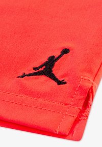 Κόκκινο βαμβακερό πουκάμισο με μαύρο κεντητό λογότυπο Jumpman στο στρίφωμα και λεπτές ραφές κατά μήκος των άκρων.