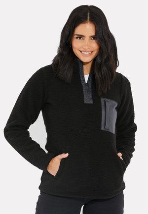 Pull noir en polaire avec une fermeture éclair quart et une poche poitrine texturée contrastante. Dispose de poches latérales et d'une texture douce et confortable.
