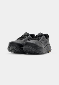 Zwarte hardloopschoenen met een gestructureerde mesh bovenkant, gevoerde kraag en Vibram-zool. Heeft logodetail aan de zijkant en contrasterende veters.