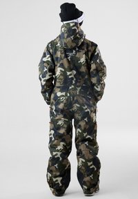 Camouflage sneeuwpak met een hoge kraag, verstelbare manchetten en ritszakken. Robuuste stof in tinten groen, bruin en zwart.