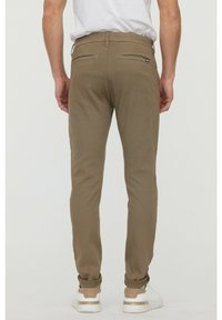 Kakhi chinos med slim fit, med två bakfickor och uppvikta ben, tillverkade av ett mjukt tyg, i kombination med vita sneakers.