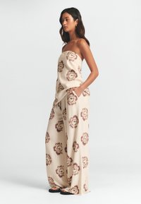 Linnesammetsbyxa med strapless-design, med en beige bas och mörkbruna blommönster. Bredbenad silhuett med sidofickor.