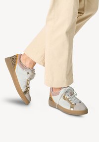 Sneakers bianchi in pelle con accenti dorati e stampa leopardata sul tallone. Presentano lacci bianchi, una linguetta imbottita e una suola testurizzata.