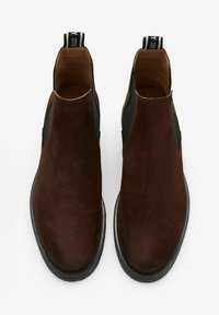 Bruine suède chelsea-boots met elastische zijpanelen, ronde neus en een zwarte rubberen zool. Merken op de aantreklip aan de achterkant.