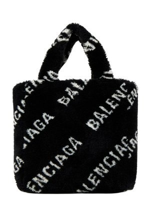 Sort pelsagtig tote-taske med korte håndtag, med gentagne hvide "Balenciaga" tekst trykt diagonalt på overfladen.