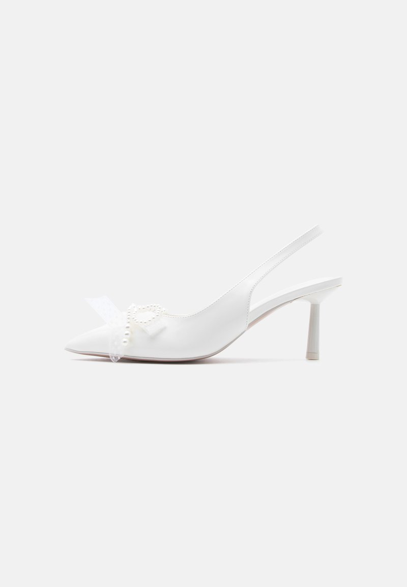 Λευκό μυτερό slingback γόβα με χαμηλό τακουνάκι, διακοσμημένη με καρδιά από μαργαριταρένιες χάντρες και φιόγκο στο πάνω μέρος.