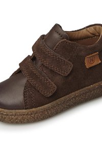 Scarpa in suede e pelle marrone con due strap in Velcro, suola in gomma marrone testurizzata e una piccola etichetta logo color sabbia sul lato.
