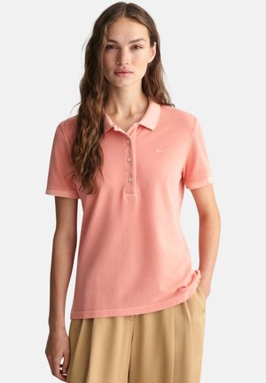 Polohemd aus weichem rosa Baumwollstoff mit Kragen, drei Knöpfen und kurzen Ärmeln. Mit einem dezenten Logo auf der linken Brust.