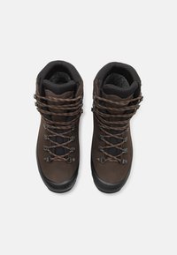 Bottines de randonnée en cuir marron avec des accents noirs, dotées d'œillets en métal, de lacets marron et de semelles texturées pour une meilleure traction. Design à bout rond.