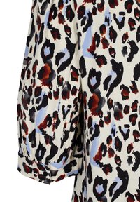 Blouse à imprimé léopard sur fond crème, avec des taches noires, rouges et bleues. Manches bouffantes avec détail de poignets boutonnés pour plus de texture.