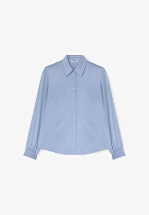 Světlomodrá halenka s dlouhými rukávy, zapínaná na knoflíky, s špičatým límcem a manžetami, položena na bílém pozadí.