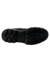 Svart lädersko med en texturerad gummisula som har djupa spår och cirkulära mönster. Siddragkedja för enkel påtagning.