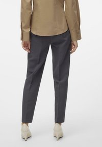 Szare, dopasowane spodnie o prostym kroju, charakteryzujące się gładką fakturą i średnim stanem, zestawione z jasnymi szpilkami.