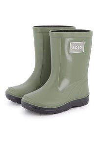 Πράσινες καουτσούκ βροχομπότες με υφασματική μαύρη σόλα, διακοσμημένες με μια ασημένια ετικέτα λογότυπου στην εξωτερική πλευρά και με λεία επιφάνεια.