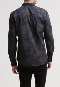 Camicia a maniche lunghe in tessuto blu navy scuro con motivo floreale in tonalità di rosso e grigio, con colletto e polsini con bottoni.