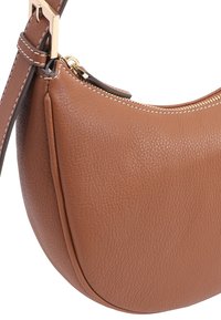 Tan leren handtas met een ronde vorm, voorzien van een gouden rits en schouderband. De stikdetails verbeteren de textuur.