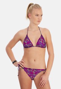 Bikini violet avec un motif floral, comprenant un haut triangulaire et un bas à nœud ajustable. Tissu lisse avec des fines bretelles et une couverture minimale.
