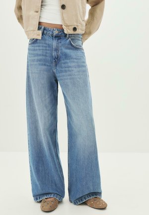 Light blue, wide-leg jeans made of denim, featuring a high waist, belt loops, and front pockets. The hem is slightly frayed.