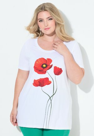 T-shirt en coton blanc avec un design de fleur de coquelicot rouge vif et des tiges vertes. Manches courtes et col rond avec une coupe décontractée.