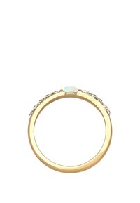 Goldring mit einem zentralen Opalstein, akzentuiert mit kleinen klaren Edelsteinen entlang des Bandes, glatte Oberfläche und runde Form.