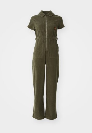 Olive green corduroy jumpsuit with a zip front, short sleeves, two chest pockets, and adjustable side straps. Flared leg design.