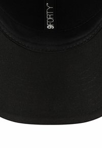 Schwarze 9FORTY-Cap mit gebogenem Schirm. Hergestellt aus Strukturstoff und mit einem gestickten Logowappen innen. Einfaches Design, keine sichtbaren Akzente.