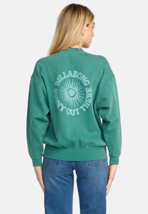Groene oversized sweatshirt van een katoenmix, met een cirkelvormige zonafbeelding en de tekst "BILLABONG SUNNY OUT THERE" op de achterkant.
