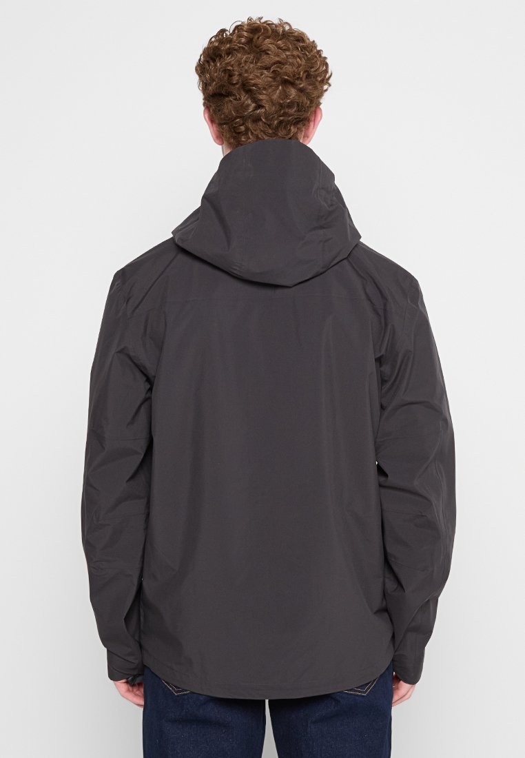 Chaqueta impermeable de color gris oscuro con capucha, que presenta una textura suave, un diseño de hombros sin costuras y un dobladillo trasero ligeramente alargado.