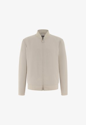 Hellbeige Bomberjacke mit einem Frontreißverschluss, geripptem Kragen, Bündchen und Saum, vor weißem Hintergrund dargestellt.