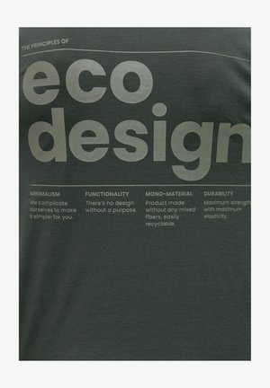 Tamna zelena majica s otisnutim bijelim tekstom koji opisuje principe ekološkog dizajna, uključujući minimalizam, funkcionalnost i izdržljivost.