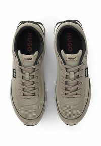 Sneaker con lacci in un beige opaco e mesh grigio con dettagli in pelle, dotate di una parte superiore testurizzata, collo imbottito e logo "HUGO".