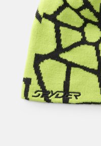 Chapeau tricoté vert néon avec un motif de toile d'araignée noire et "Stryder" brodé en noir. Bords renforcés pour plus de durabilité.