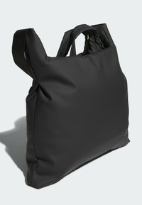 Čierna kabelka typu tote z hladkého materiálu s minimalistickým dizajnom, vybavená dvoma rukoväťami a jemnými značkovými detailmi na boku.