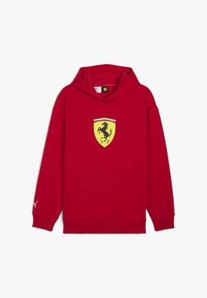 Felpa con cappuccio rossa che presenta un emblema giallo della Ferrari sulla parte anteriore, con un logo bianco della Puma sulla manica sinistra.