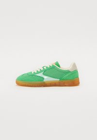 Grønne sneakers med net- og ruskindmaterialer, med hvide accenter, kremfarvede snørebånd og en gennemsiktig oransje gummisåle.
