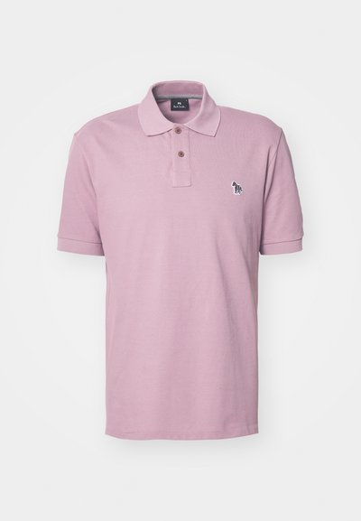 Polo em rosa claro feito de algodão, apresentando uma lista de dois botões e um logótipo de animal bordado no lado esquerdo do peito. Mangas curtas.