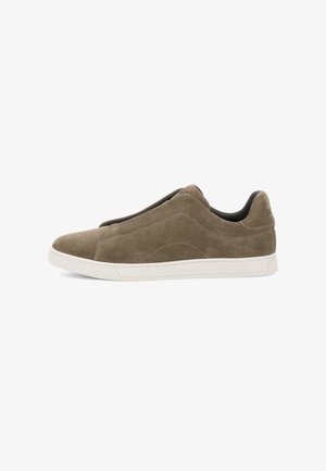Zapinane sneakers w oliwkowej zamszowej skórze, z białą gumową podeszwą, gładką teksturą i subtelnymi detalami przeszycia, które nadają elegancki wygląd.