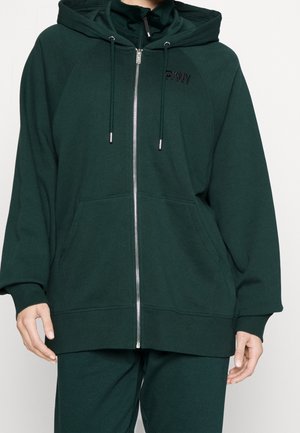 Ciemnozielona, luźna bluza z kapturem na zamek z regulowanym sznurkiem, kieszeniami z przodu, ściągaczami na mankietach oraz subtelnym logo DKNY na lewej piersi.