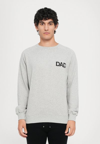 Grå sweatshirt med rund hals og lange ærmer. Inkluderer et sort trykt "DAD" logo på venstre side af brystlommen. Glat tekstur.