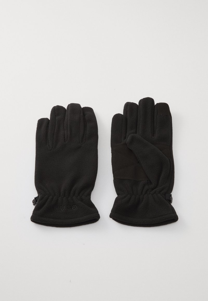 Gants en polaire noire avec une finition texturée, dotés de poignets élastiques et d'un logo subtil embossé au niveau du poignet. Design de doigts notable pour une dextérité optimale.