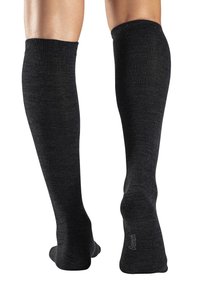 Knielange schwarze Socken aus einem strukturierten Stoff mit gerippten Bündchen und einer glatten Oberfläche. Dezentes Branding an der Sohle.