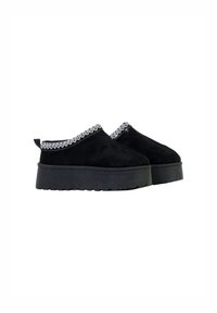 Scarpe senza lacci in suede nero con suola platform nera spessa e cuciture decorative bianche attorno al collo. Tessuto liscio, senza elementi hardware visibili.