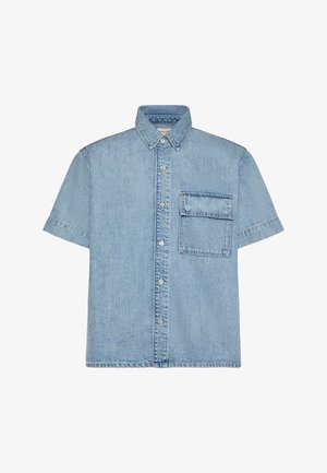 Camisa vaquera azul celeste de manga corta con botones delanteros y un gran bolsillo cuadrado en el pecho izquierdo.