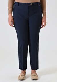 Pantaloni su misura color blu navy con una texture liscia, dotati di chiusura frontale con bottone, tasche laterali e un design a gamba slim affusolata.