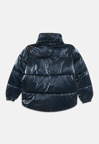 Mørkeblå pufferjakke med en blank, vandtæt finish, forsynet med en høj krave, elastiske manchetter og en boxy silhuet.