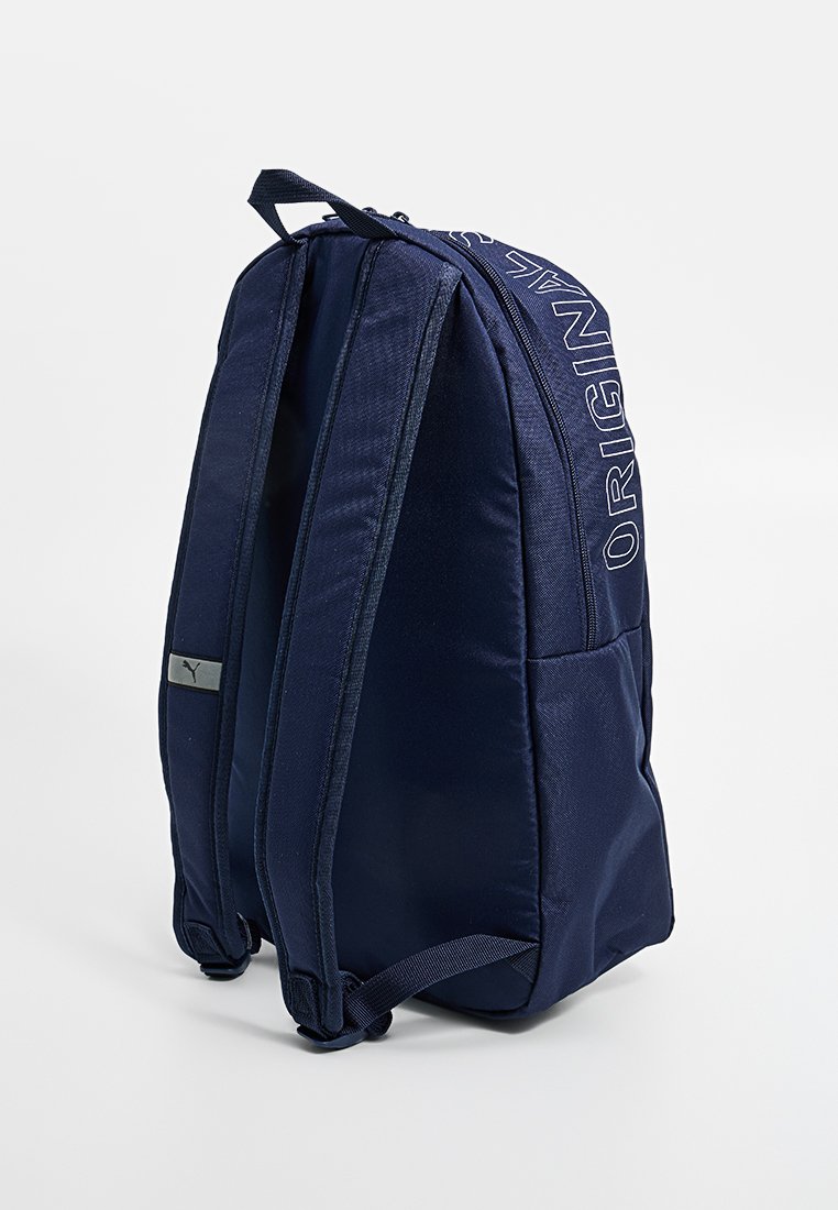 Mochila azul marino con correas de hombro acolchadas, bolsillo lateral, asa superior y la palabra "ORIGINAL" impresa a lo largo del borde superior.