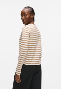 Randig långärmad topp i beige och krämfärgat, med rund halsringning och rak passform. Mjukt bomullstyg med slät yta.